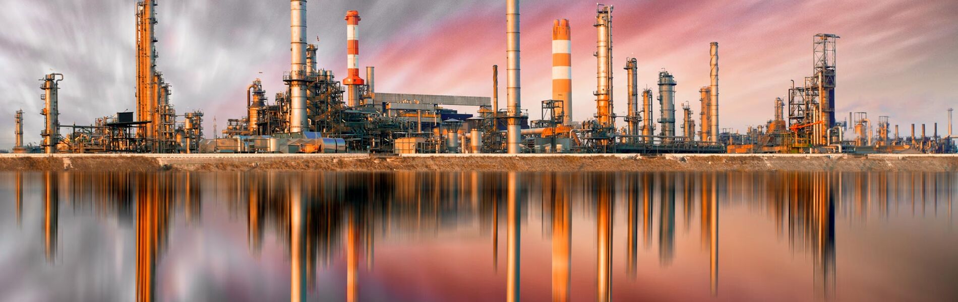 Offshore oil and gas industry with piping and valves, worker in foreground